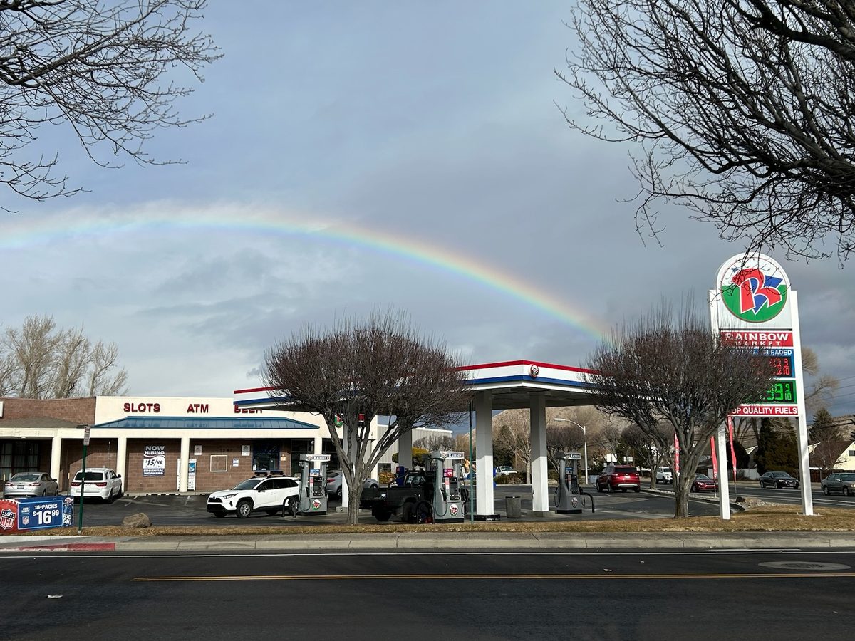 Rainbow Market convenience store and fuel pumps, with a rainbow overhead